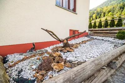 a rock garden in front of a house at Country House Sara in Rečica ob Savinji
