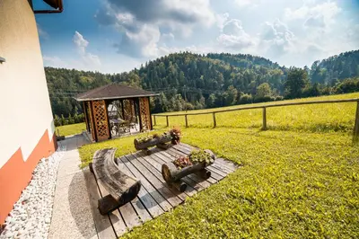 a wooden deck with a gazebo in a field at Country House Sara in Rečica ob Savinji