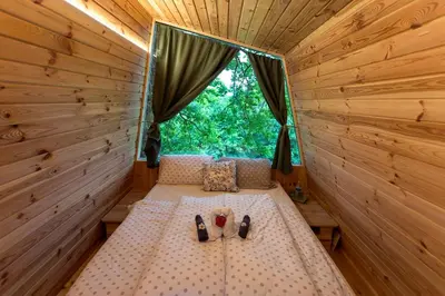 a room with a bed in a wooden cabin with a window at Glamping Health Resort in Kamnik