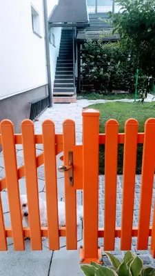 an orange fence in front of a house at Family Apartment NAKITEYA in Ljubljana