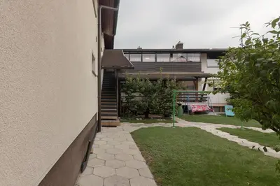 a side view of a house with a yard at Family Apartment NAKITEYA in Ljubljana