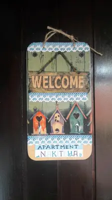 a welcome sign is hanging on a door at Family Apartment NAKITEYA in Ljubljana