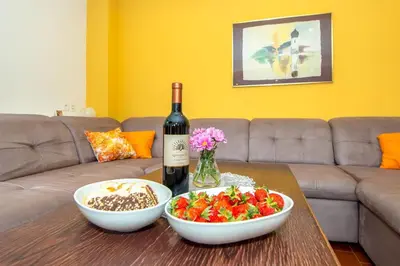 a bottle of wine and a bowl of fruit on a table at Gorgeous Chalet in Bled