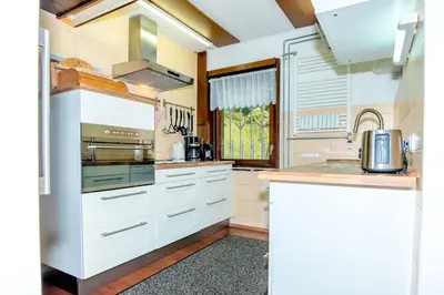 a kitchen with white cabinets and a sink at Gorgeous Chalet in Bled