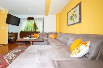 a living room with a gray couch with orange pillows at Gorgeous Chalet in Bled