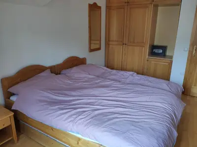 a bed in a bedroom with a purple blanket at Antela appartments for up to 5 person on Mariborsko Pohorje in Pohorje