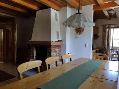 a dining room with a table and chairs and a fireplace at Antela, 142 m2 appartment for 12 person in Mariborsko Pohorje in Pohorje