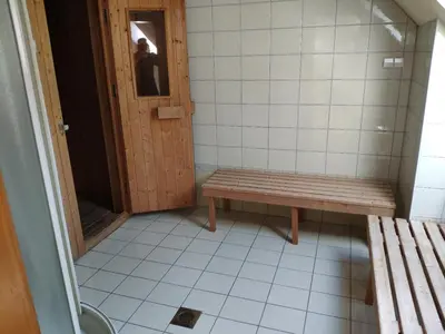 a small bathroom with a bench and a door at Antela, 142 m2 appartment for 12 person in Mariborsko Pohorje in Pohorje