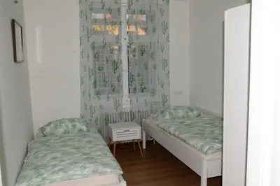 two beds in a room with curtains and a table at Flower valley in Ljubljana