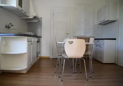 a kitchen with white cabinets and a table and chairs at Flower valley in Ljubljana
