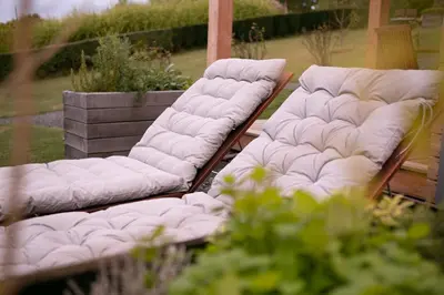 a couple of white couches sitting on a porch at Hišice Čarna - Houses Čarna in Puconci