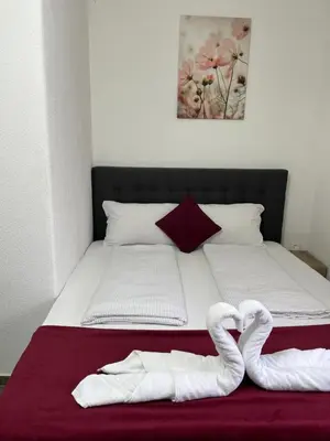 a bed with two white towels on top of it at Panda Rooms in Maribor