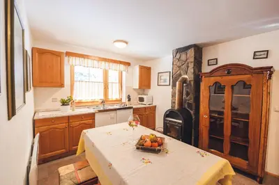 a kitchen with a table with a bowl of fruit on it at POHORJE HOUSE Rogla 2 in Oplotnica