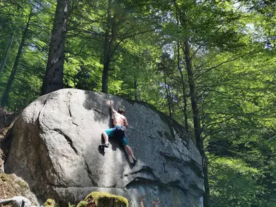 a man is climbing on a large rock at POHORJE HOUSE 2 FOUR APPARTMETNS in Oplotnica
