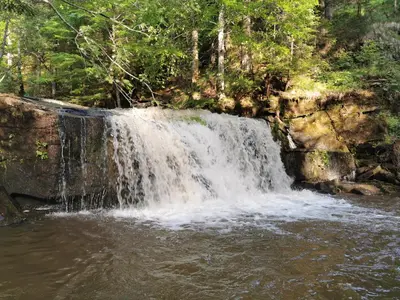 a waterfall on the side of a river at POHORJE HOUSE 2 FOUR APPARTMETNS in Oplotnica