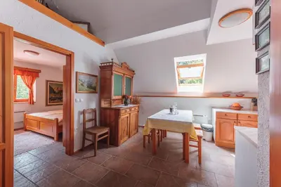 a kitchen with a table and a dining room at POHORJE HOUSE 2 FOUR APPARTMETNS in Oplotnica
