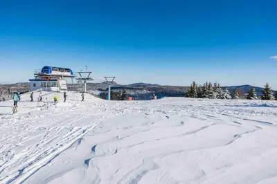 a group of people skiing on a snow covered slope at POHORJE HOUSE 2 FOUR APPARTMETNS in Oplotnica
