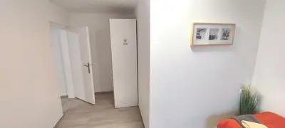 a hallway with white walls and a white door at JO-MA apartma - SAFE parking in Koseze