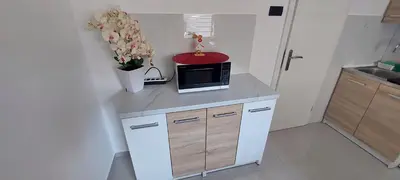 a kitchen with a microwave on a counter with flowers at JO-MA apartma - SAFE parking in Koseze