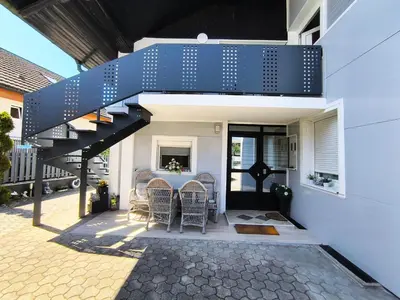 a house with a blue staircase on a patio at JO-MA apartma - SAFE parking in Koseze