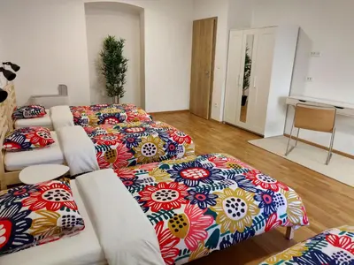 a living room with three beds and a couch at PUBYLAND ROOMS & APARTMENTS in Rogatec