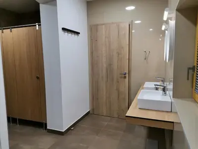 a bathroom with a sink and a wooden door at PUBYLAND ROOMS & APARTMENTS in Rogatec