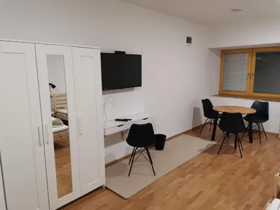 a room with a table and chairs and a tv at PUBYLAND ROOMS & APARTMENTS in Rogatec