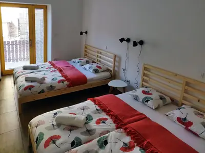 two twin beds in a room with a window at PUBYLAND ROOMS & APARTMENTS in Rogatec