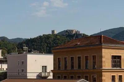 a building with a mountain in the background at NEW, Stylish and modern central Studio, FREE parking in Celje