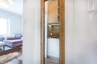 a mirror in a living room with a couch at NEW, Stylish and modern central Studio, FREE parking in Celje