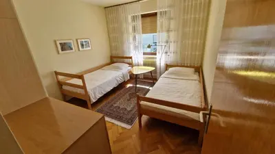 a small room with two beds and a window at Apartment Ajdna in Žirovnica