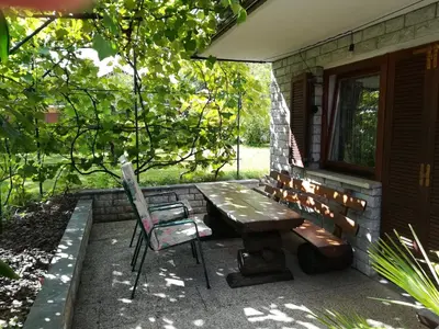 a picnic table and a chair outside of a house at Apartment Ajdna in Žirovnica