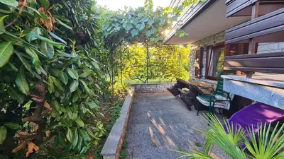 a garden with two benches and a building at Apartment Ajdna in Žirovnica