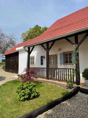 a small white house with a red roof at Domačija Pri Momi in Križevci