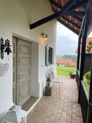 a patio with a door and a chair on a porch at Domačija Pri Momi in Križevci