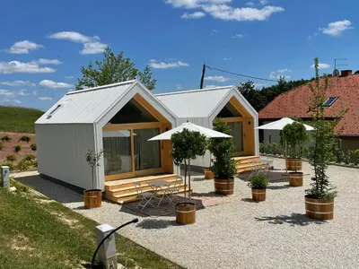 a small white shed with a table and an umbrella at Domačija Pri Momi in Križevci
