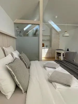 a large white bed with pillows on it in a room at Domačija Pri Momi in Križevci