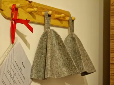 two bells hanging on a wall with a red ribbon at Mountain peaks Apartment with Sauna in Gozd Martuljek