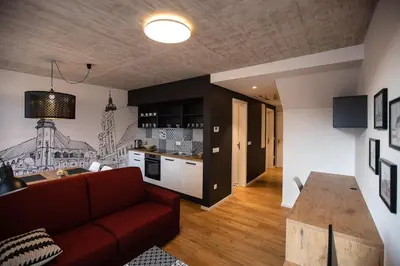 a living room with a red couch and a kitchen at Postcard City Apartments in Maribor