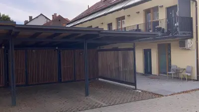 a building with a patio with a fence and a balcony at Postcard City Apartments in Maribor