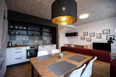 a kitchen and dining room with a wooden table at Postcard City Apartments in Maribor
