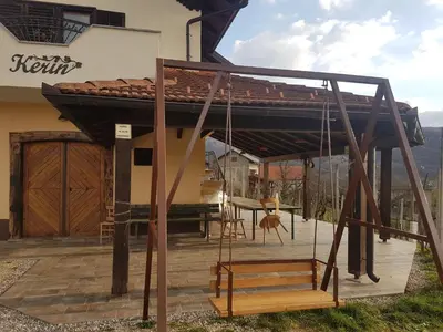 a house with a porch with a swing at Holiday Home Kerin in Cerklje ob Krki