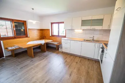 a kitchen with white cabinets and a wooden table at Holiday Home Kerin in Cerklje ob Krki
