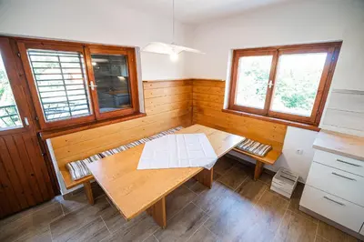 a room with a wooden table and two windows at Holiday Home Kerin in Cerklje ob Krki