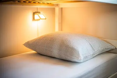 a pillow sitting on a bed next to a lamp at Holiday Home Kerin in Cerklje ob Krki