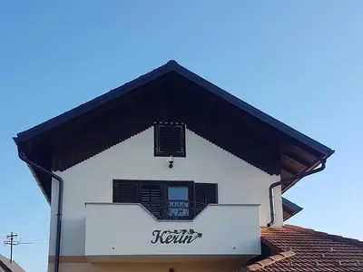 a white building with a balcony and a sign on it at Holiday Home Kerin in Cerklje ob Krki