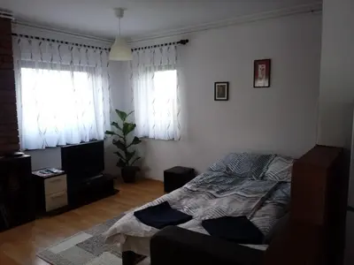 a bedroom with a bed and two windows at Sunrise Home in Maribor