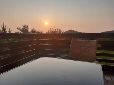 a table and chairs on a balcony with the sunset at Sunrise Home in Maribor