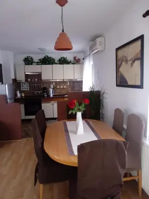 a dining room table with a vase of flowers on it at Sunrise Home in Maribor