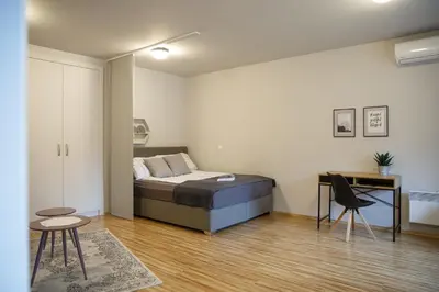 a bedroom with a bed and a table and chairs at Apartment Nobl plac in Celje